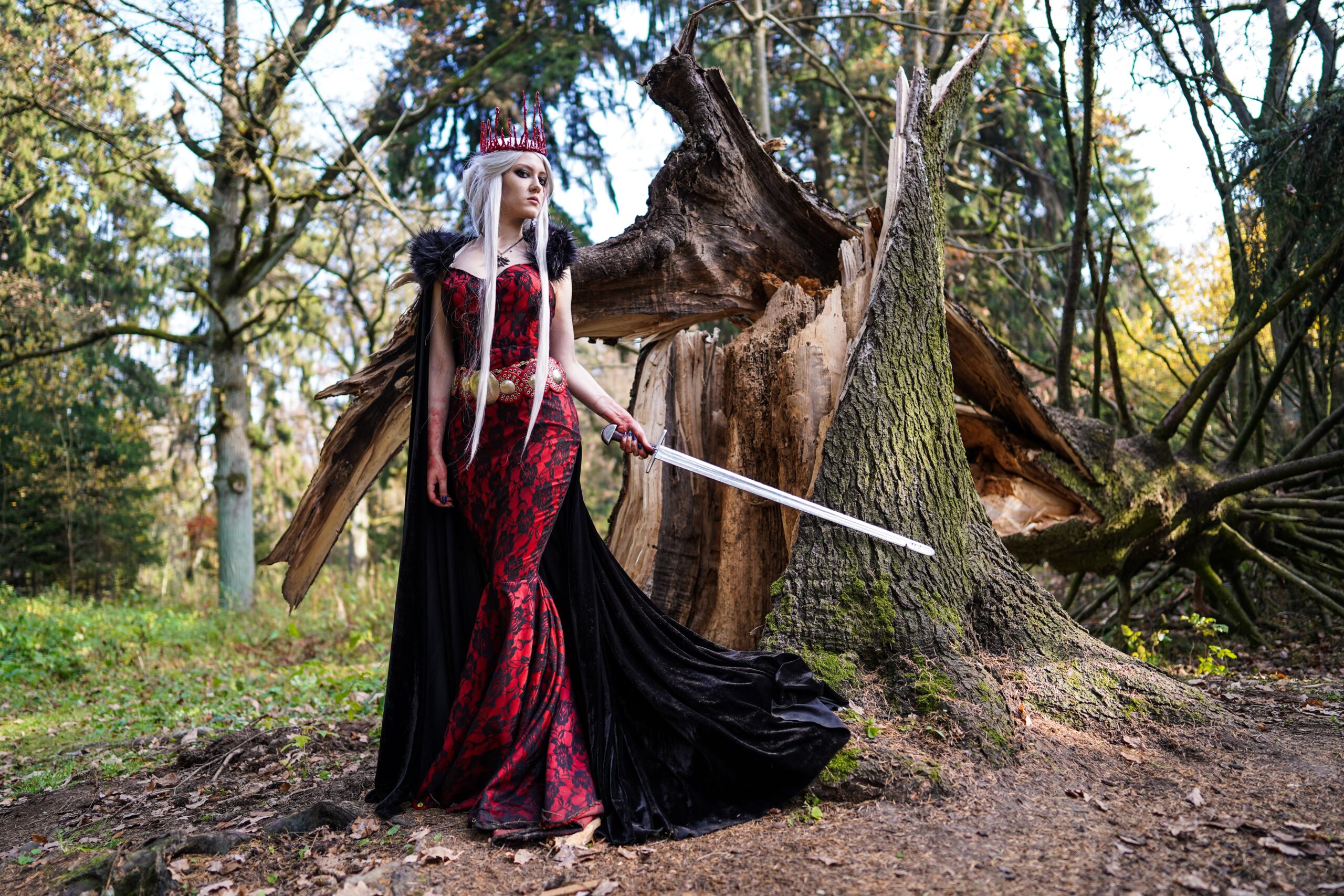 woman with sword before fallen tree