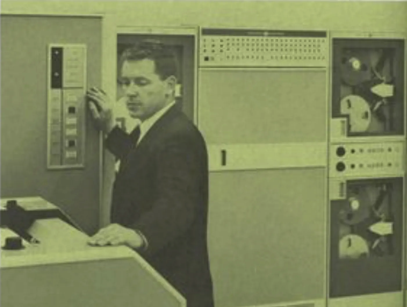 man standing before a GE 235 computer