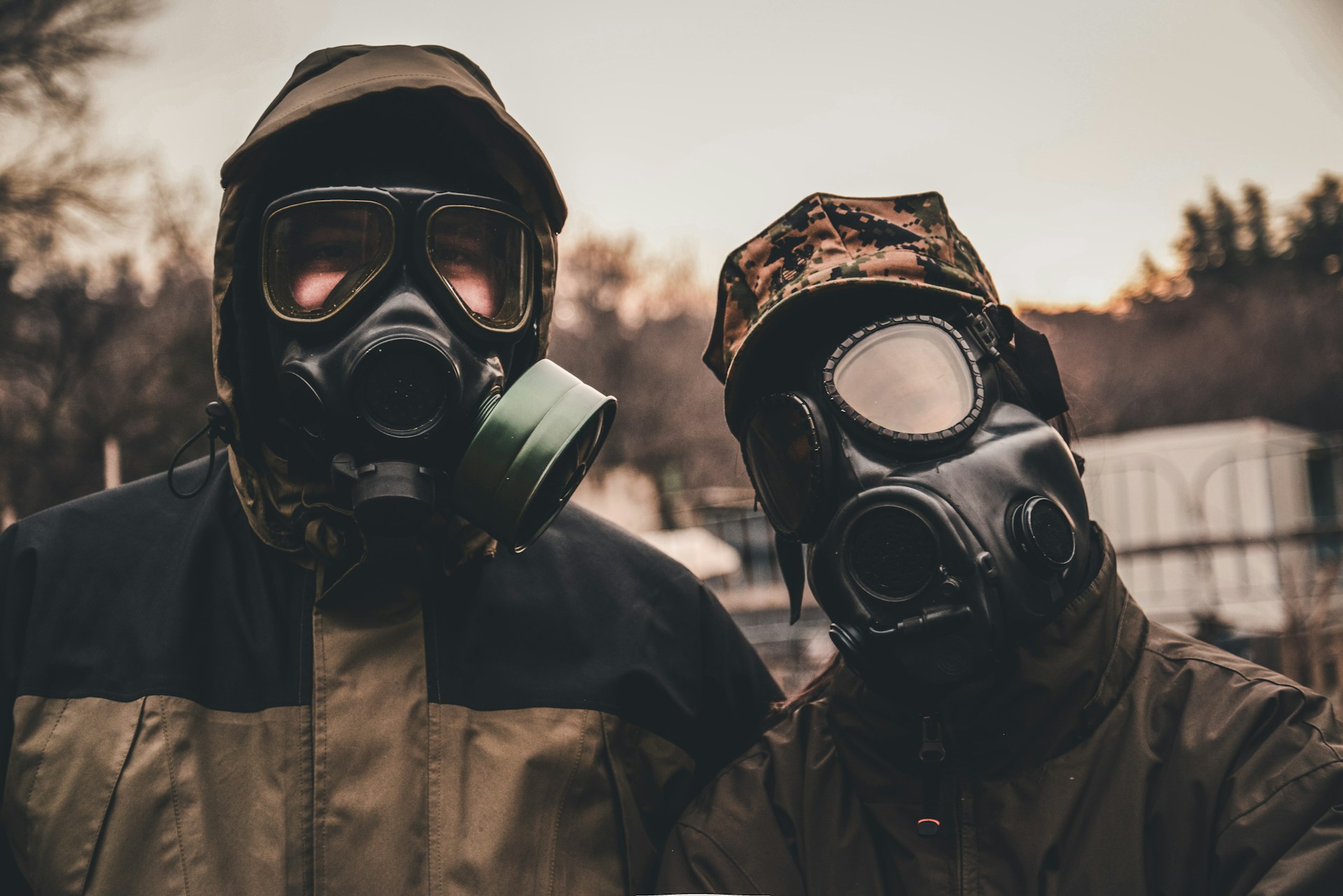 Two figures wearing gas masks